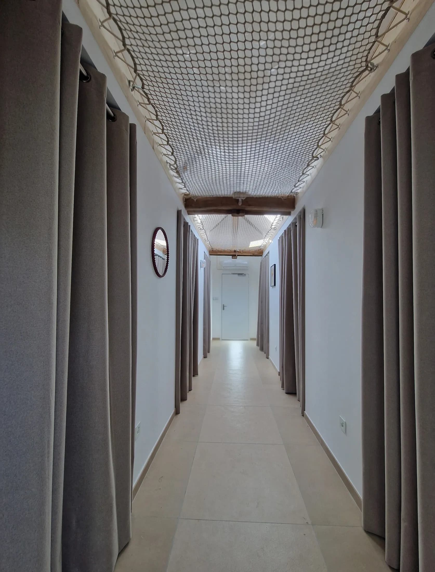 Couloir des alcôves privatives à l'étage, sous les filets de détente